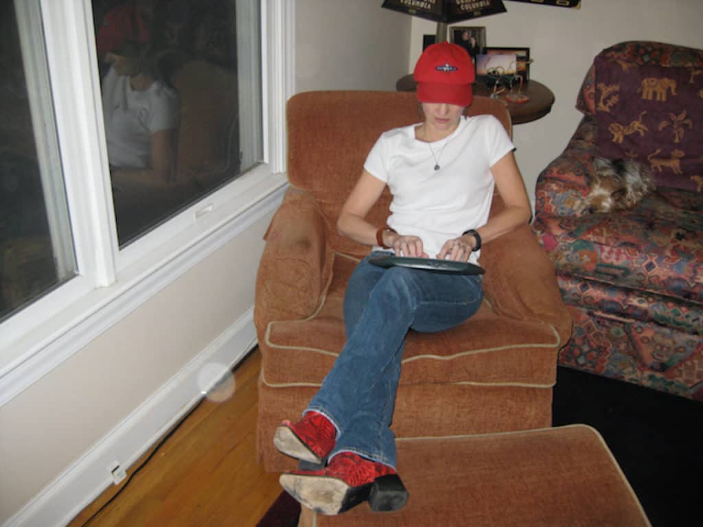a picture of the author in an arm chair, typing about three books and a play
