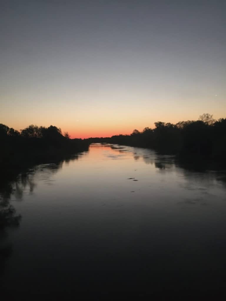 Calm photo of sun setting over a wide river in hopes it will relieve any disquiet about the questions in the personal inventory to begin examining white privilege as as spiritual discipline. 