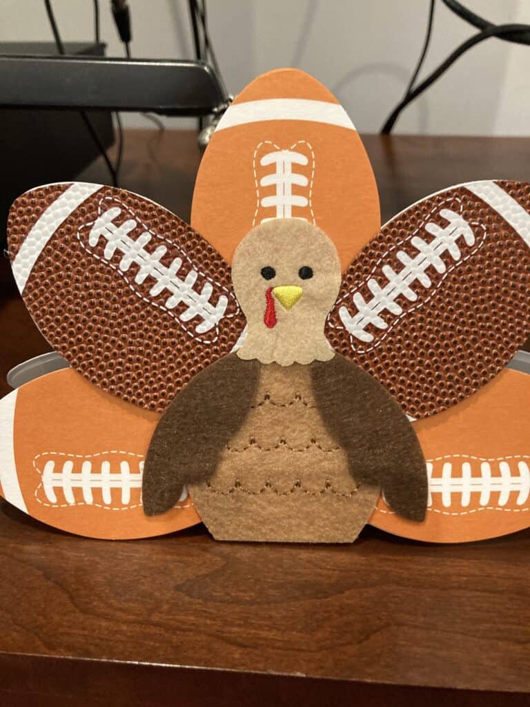 A T'giving card of a turkey made from footballs, swimming streamline through life