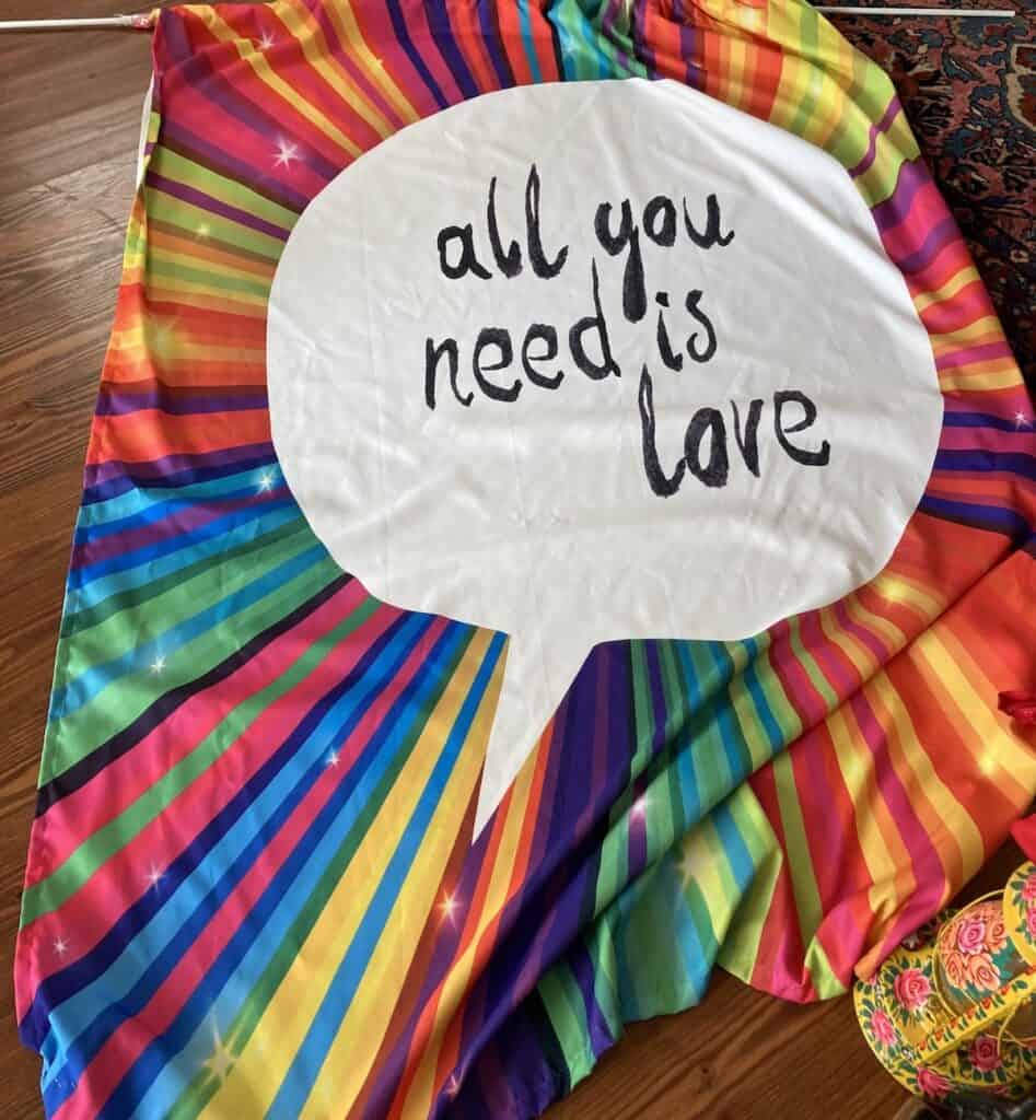 An "All You Need is Love" rainbow colored banner to appease my invisible companions