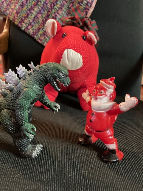 Santa, Godzilla and a large red pig square off in the spirit of let the magic be. 