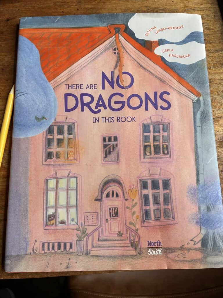 Coral and blue cover of book, There Are NO DRAGONS in this Book. Featuring a house with 5 windows and a little girl in the bottom right window looking out at us; perhaps a dragon's tail slithering from the roof
