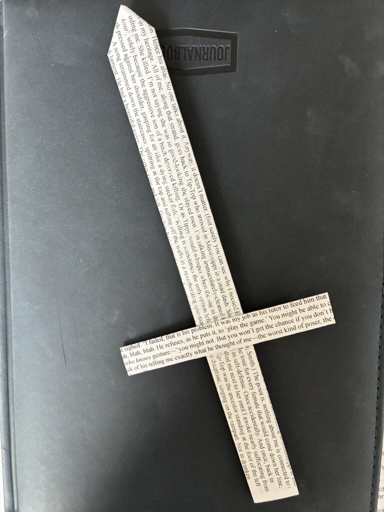A black and white paper knife bookmark made from pages printed with the words of the novel. 